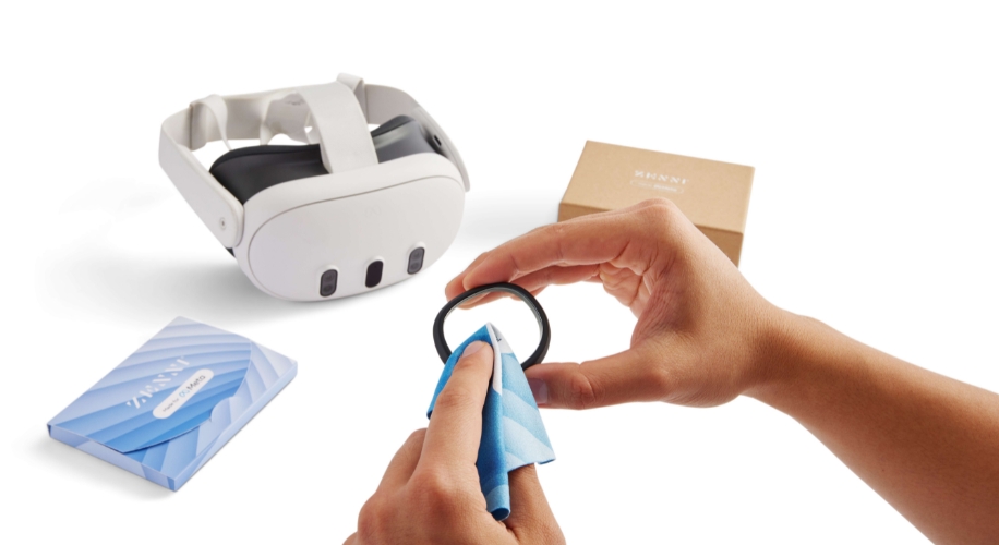 Hands cleaning VR headset lens, with headset and INNRI box in background.