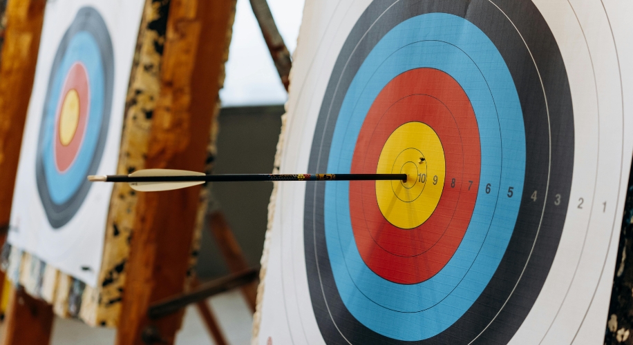 Bullseye on archery target hit by an arrow; surrounding rings are numbered 1 to 10.