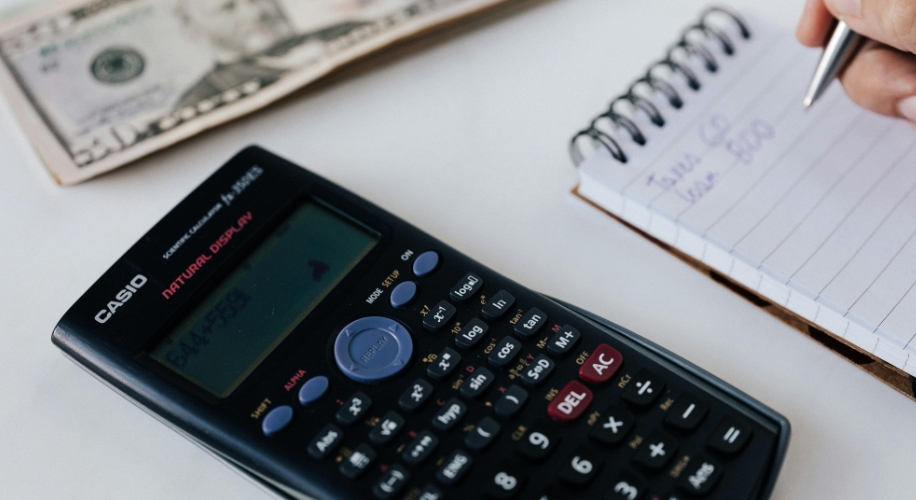 Casio calculator next to a notepad with handwritten text and a pen.