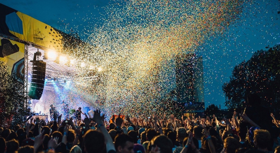 Concert stage with colorful confetti raining down on the crowd at night.