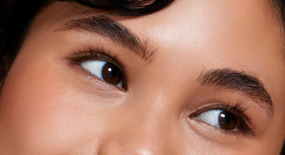 Close-up of well-groomed eyebrows shaped with a natural arch and smooth skin texture.