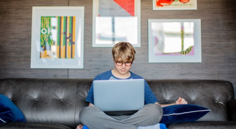 Person sitting on a couch using a laptop.