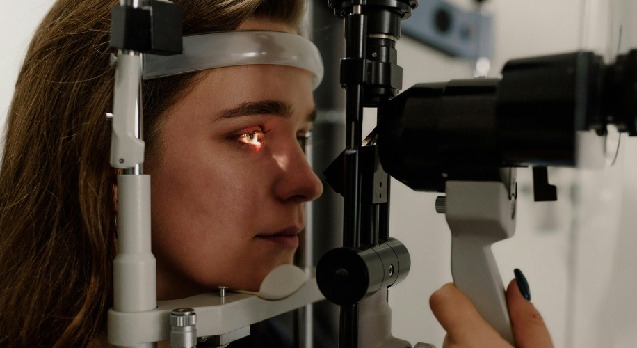 Patient receiving an eye exam using a slit lamp.