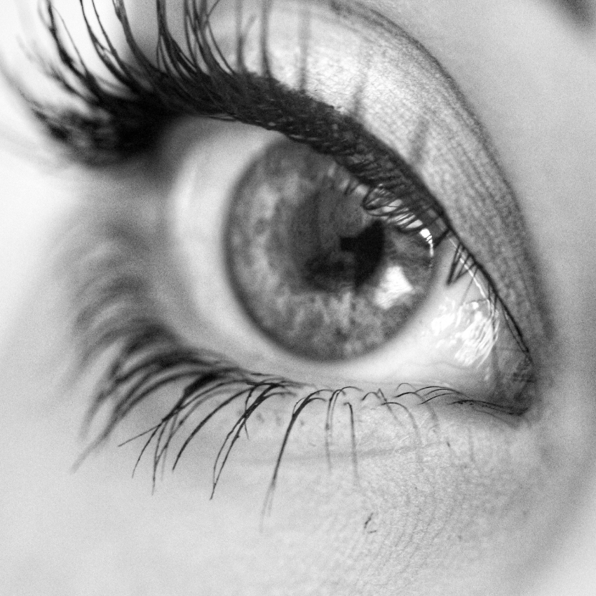 Close-up of a human eye with long, dark eyelashes and detailed iris patterns.