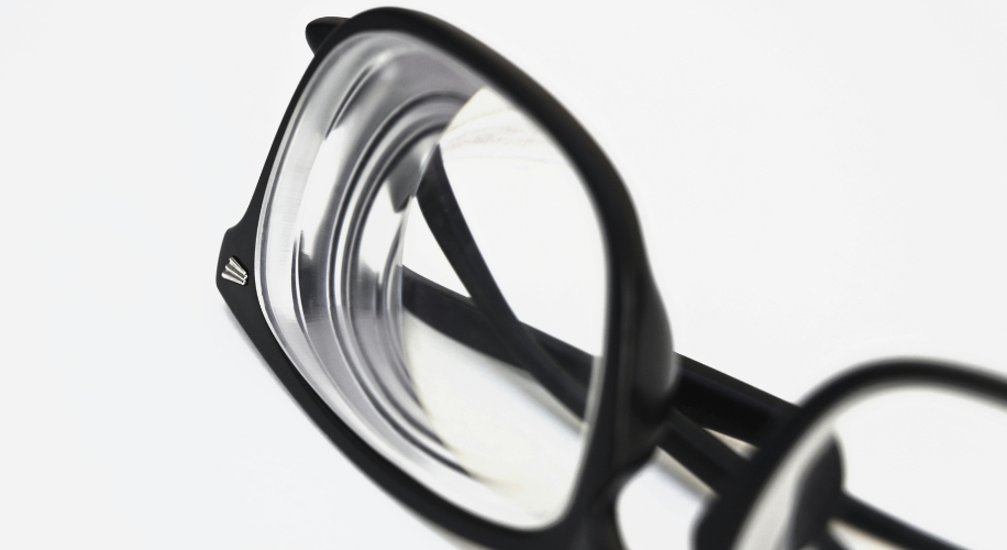 Black rectangular eyeglasses with transparent lenses and metal accent on the frame&#039;s temples.