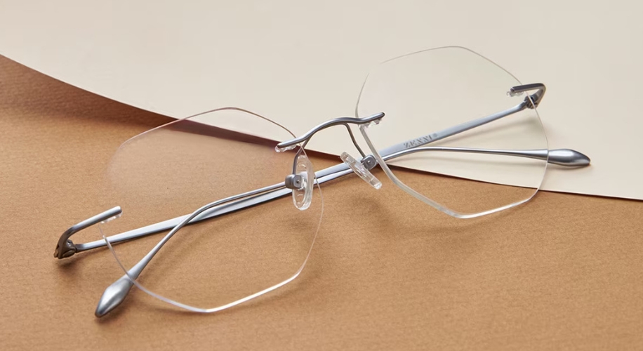 Silver, frameless hexagonal eyeglasses with transparent nose pads.