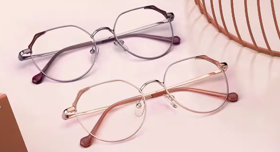 Two pairs of round metal eyeglasses with thin frames; one in silver and one in rose gold.