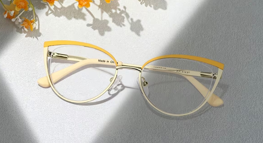 Cat-eye glasses with gold and yellow frames, white arms. Text on arm reads &quot;Made in China&quot; and &quot;ADANIP&quot;.