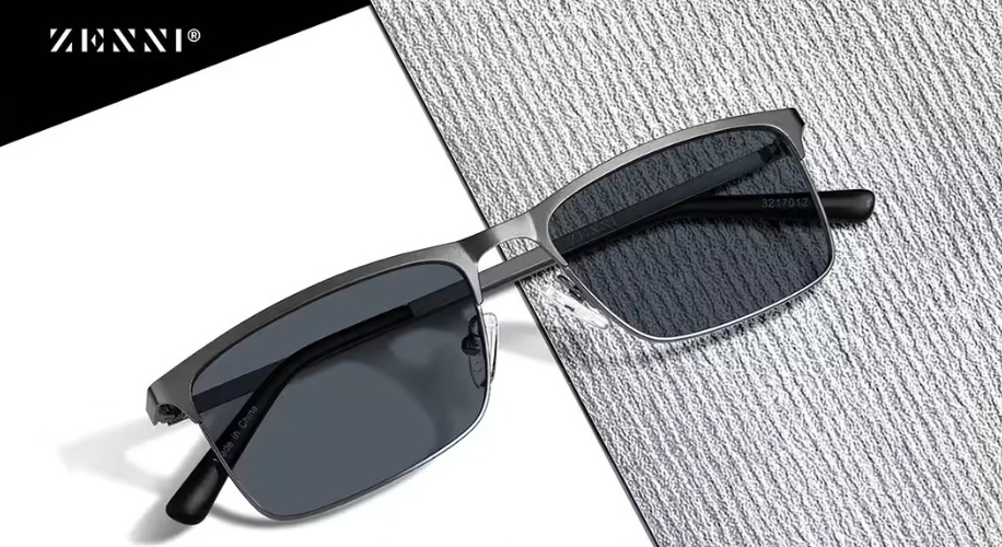 Zenni rectangular framed sunglasses with dark lenses, brushed metal bridge, and black arms laid on a textured surface.