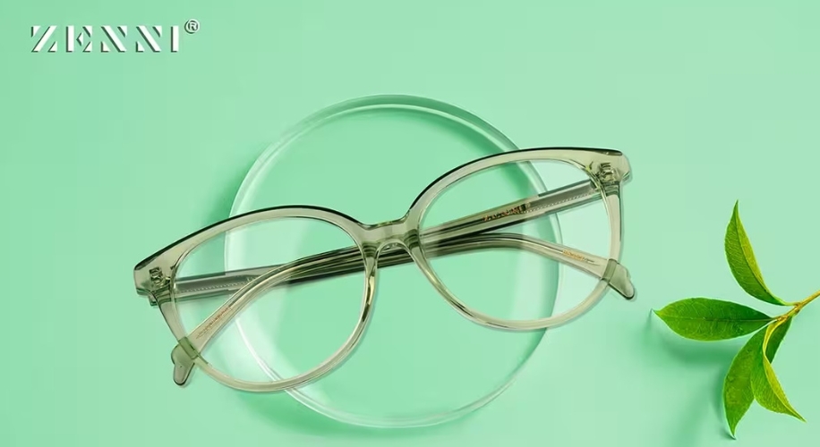 Zenni glasses with a transparent, round frame on a green background with a Zenni logo in the top left.