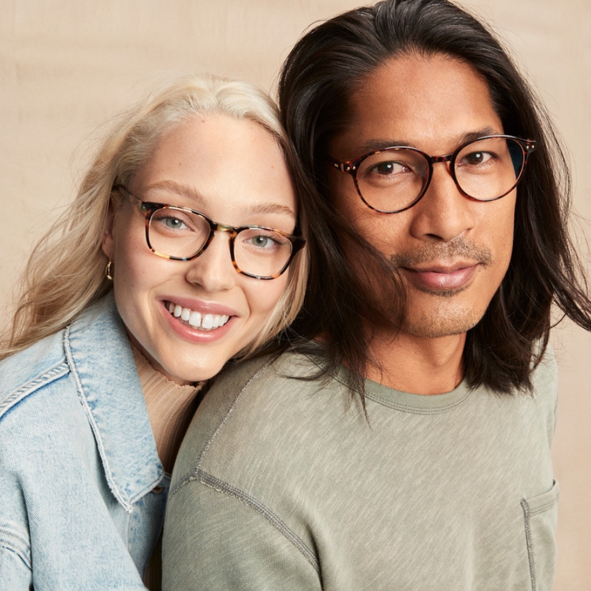 Two people wearing stylish, tortoise-shell eyeglasses and casual clothing.