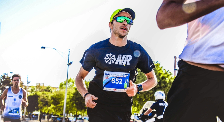 Runner wearing sunglasses, a black &quot;NR&quot; shirt, and a yellow cap; race bib number 652.