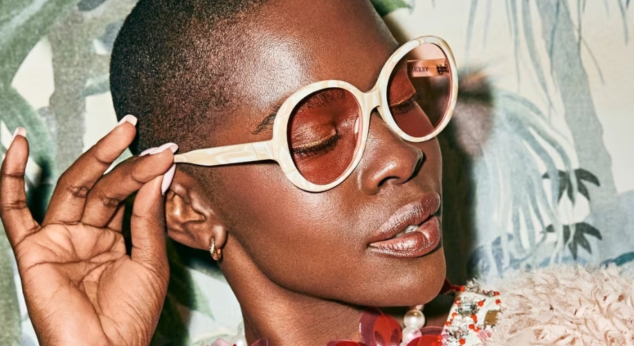 Woman wearing oversized round sunglasses with light-colored rims and lightly tinted lenses.