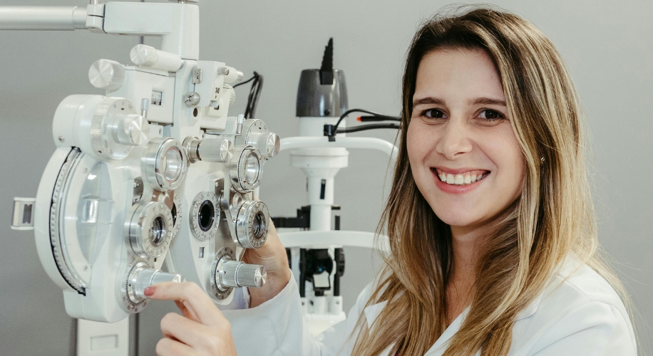 Optometrist adjusting a phoropter, an eye examination device used to determine prescriptions for eyeglasses.