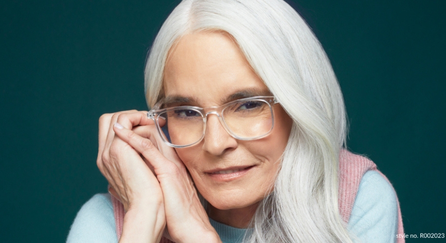 Glasses with clear frames worn by a person with long white hair. Style no. RO02023.