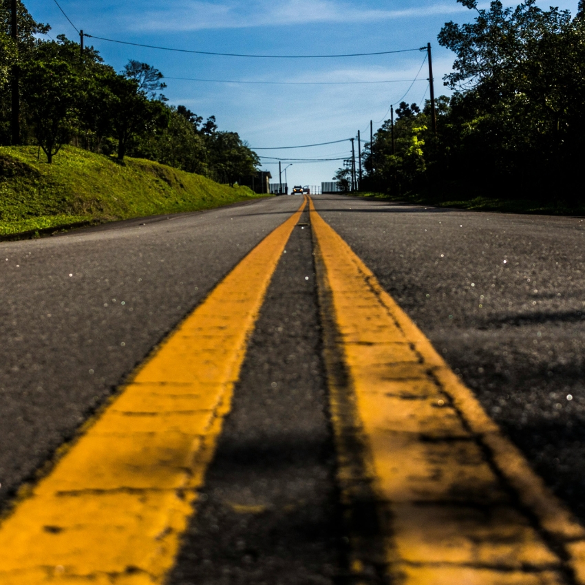 Two parallel yellow lines in the center of an empty road leading into the distance.