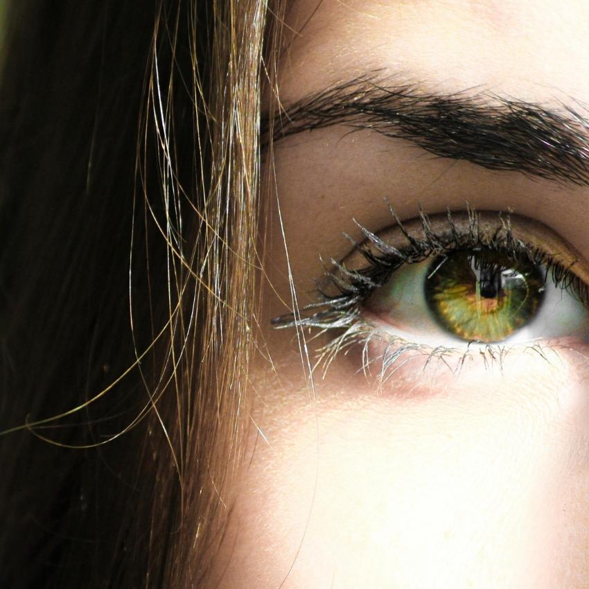 Close-up of a green eye with applied mascara.