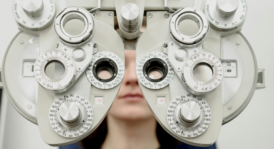 Optometry phoropter with multiple dials and lenses for eye examinations.