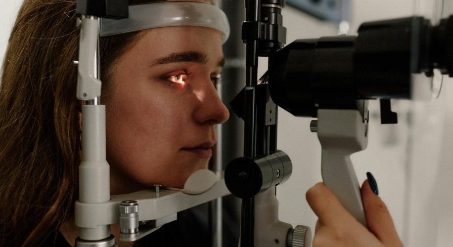 Eye exam using a slit lamp biomicroscope focusing on the patient&#039;s eyes.