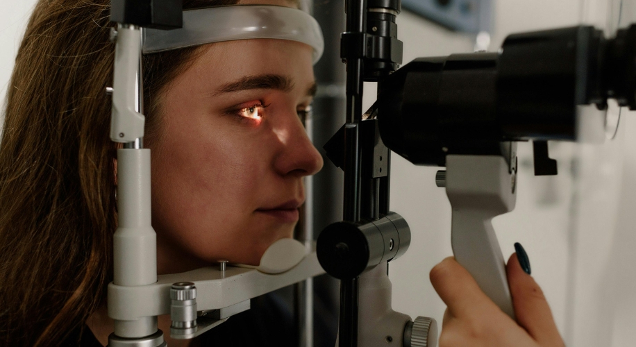 Woman undergoing an eye examination with slit lamp biomicroscope.