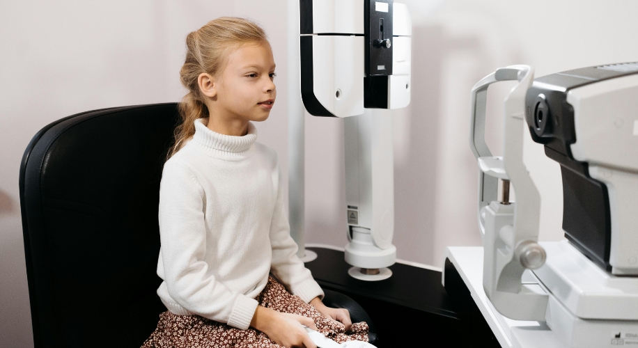 Child undergoing an eye exam with optical equipment.