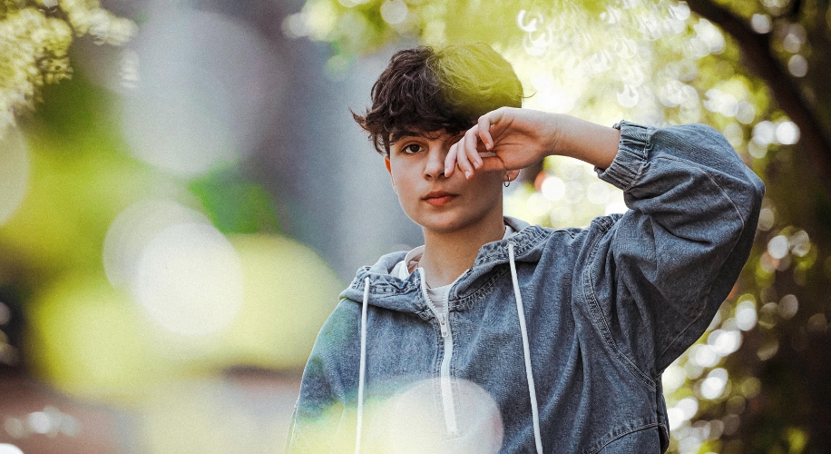 Person wearing a gray denim jacket with drawstrings.