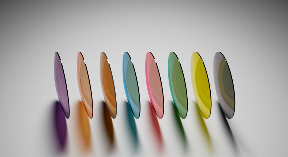 Colorful contact lenses arranged in a row, featuring shades of purple, orange, red, blue, green, yellow, and gray.