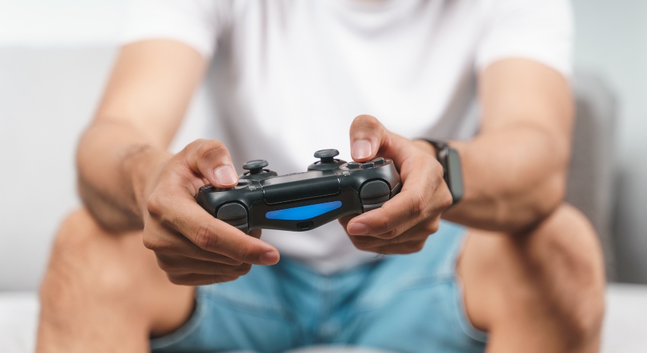 Hands holding a black game controller with blue light.