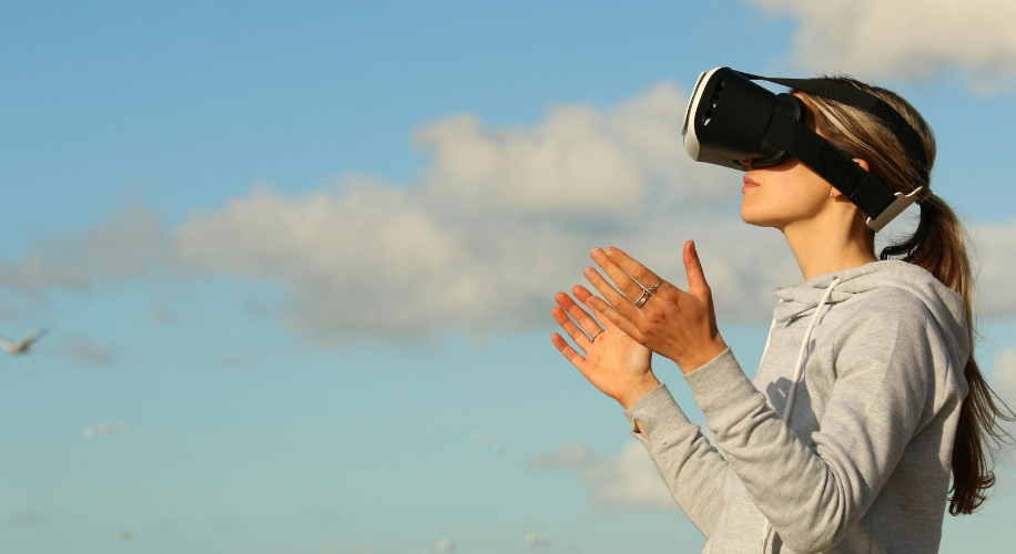 Person using virtual reality headset outdoors.