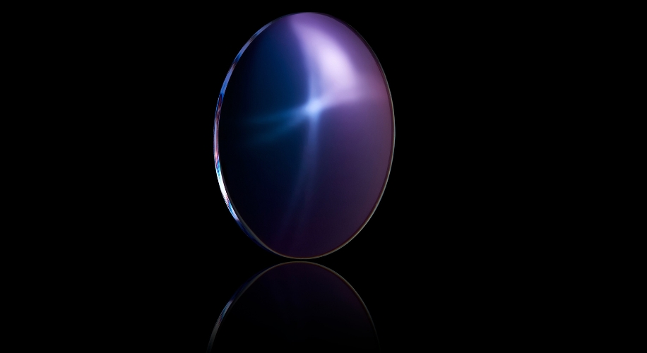 Purple gemstone with a star-like light reflection on a black background.