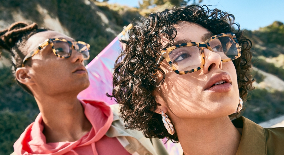 Two models wearing tortoiseshell eyeglasses.