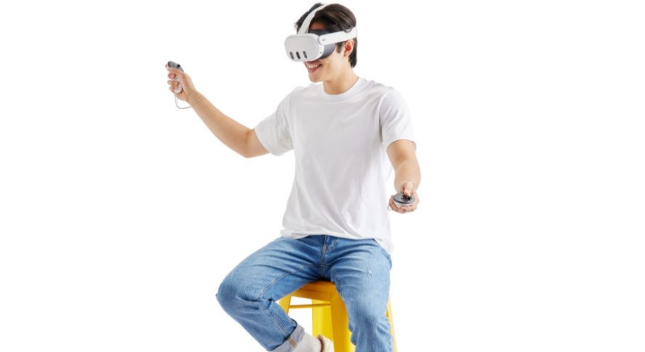 Person uses virtual reality headset and controllers while seated.