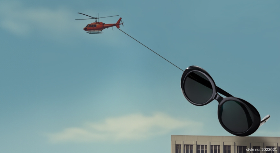 Sunglasses style no. 2023021 being transported by a red helicopter against a blue sky.