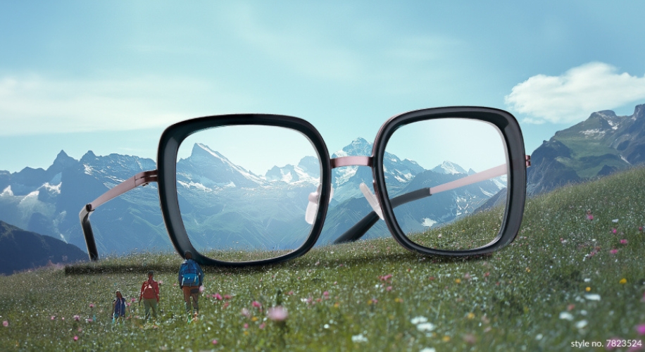 Black-rimmed square eyeglasses with pink temples on a mountain field. Text: &quot;style no. 7823524&quot;.