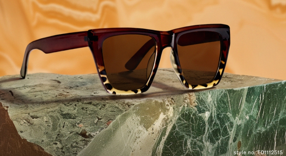 Red and beige tortoiseshell square sunglasses with brown lenses on marble slab. Text: style no. T01112515.