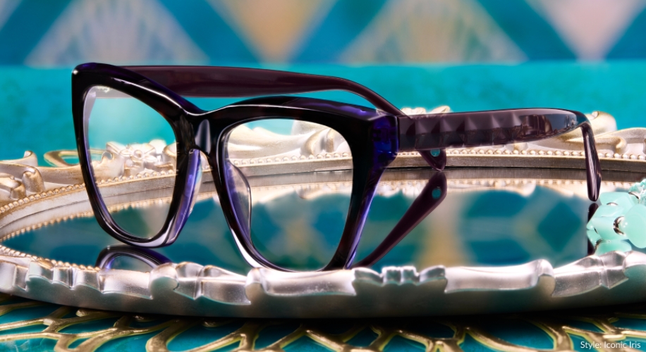 Purple rectangular eyeglasses with thick frames on a decorative silver tray. Style: Iconic Iris.