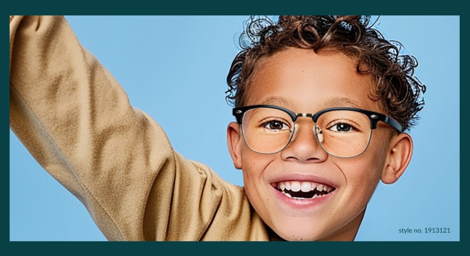 Young child wearing black-rimmed eyeglasses, style no. 1913121, smiling with a blue background.