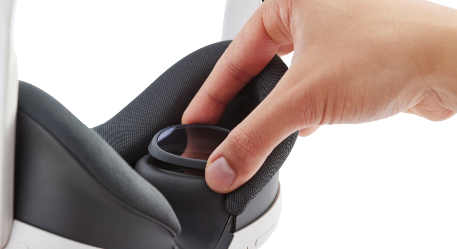 Hand adjusting a detachable lens on a VR headset.