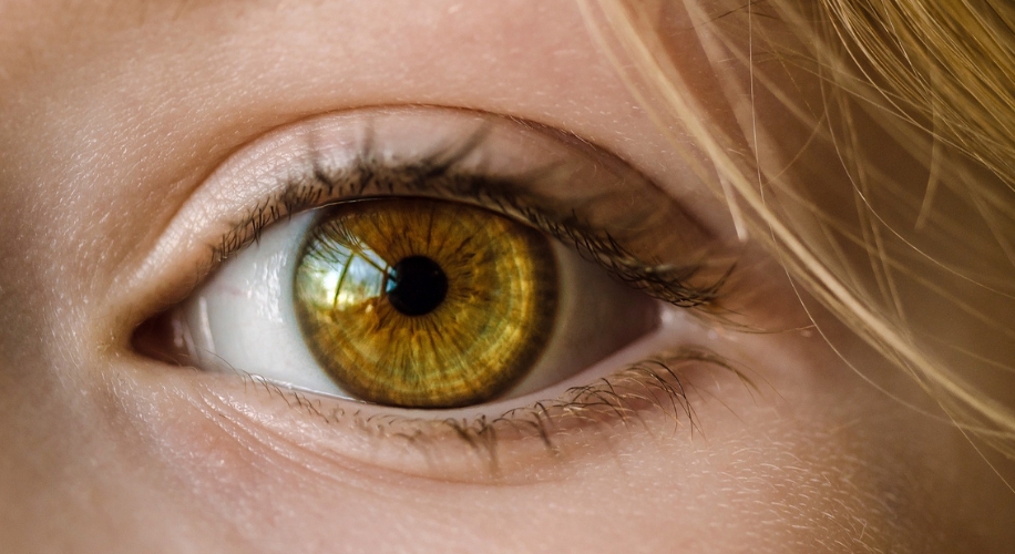 Close-up of a hazel eye with detailed iris patterns.