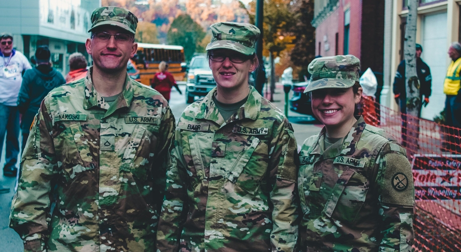 Three U.S. Army soldiers in uniform smiling at the camera. Their name tags read Nakoski, Baab, and N.S.