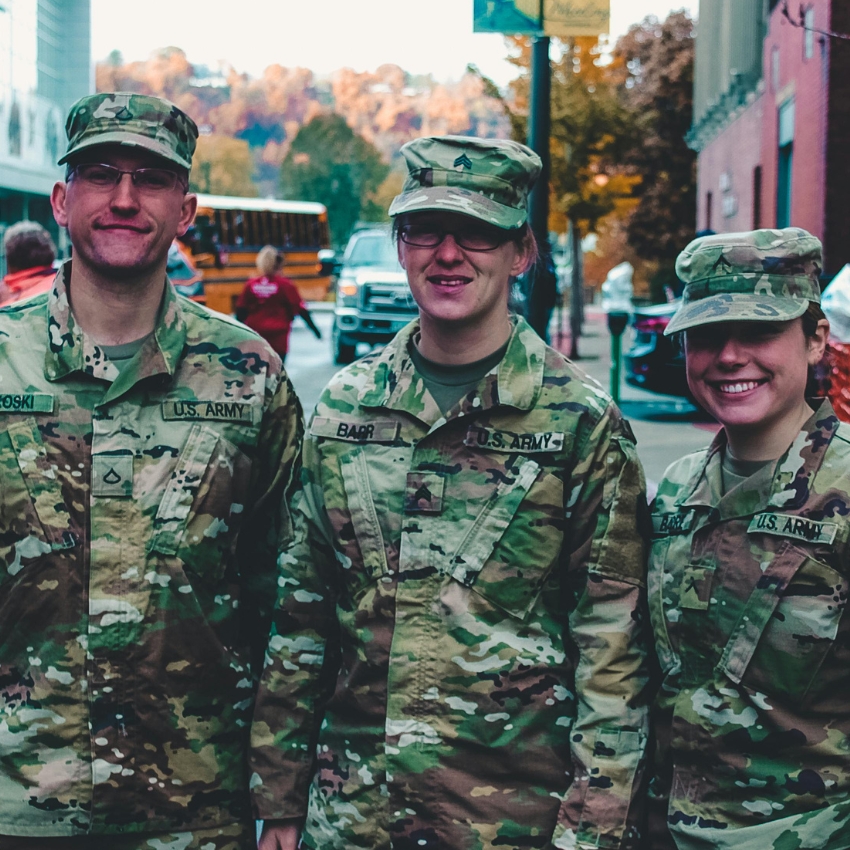 Three U.S. Army soldiers in camouflage uniforms and hats with nametags Boski, Barr, and Emlar.