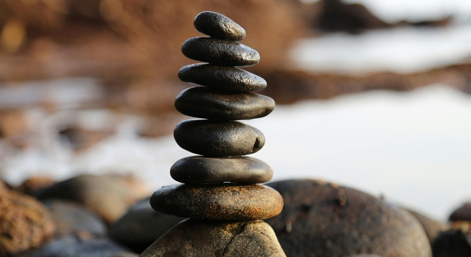 Stack of seven smooth black stones balanced on top of each other.