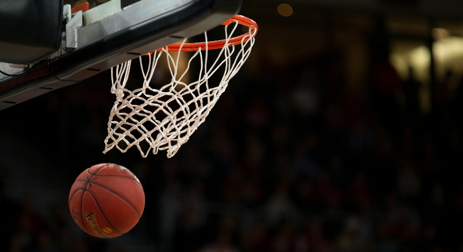 Basketball going through a hoop with a net.