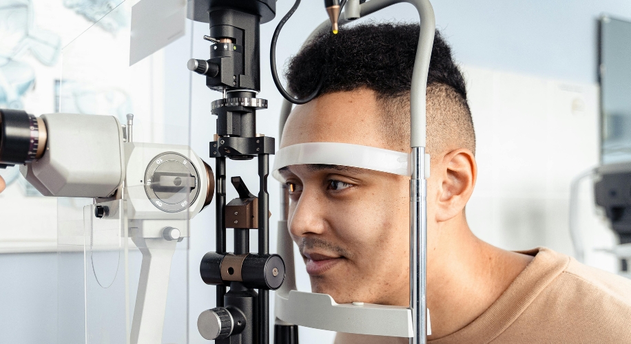 Patient using diagnostic equipment for an eye exam.