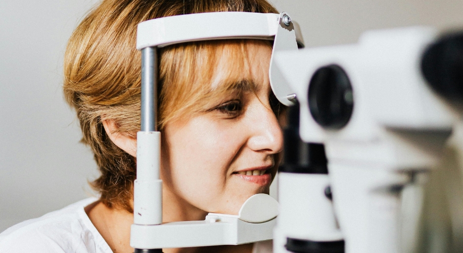 Woman undergoing an eye examination with an optical machine.