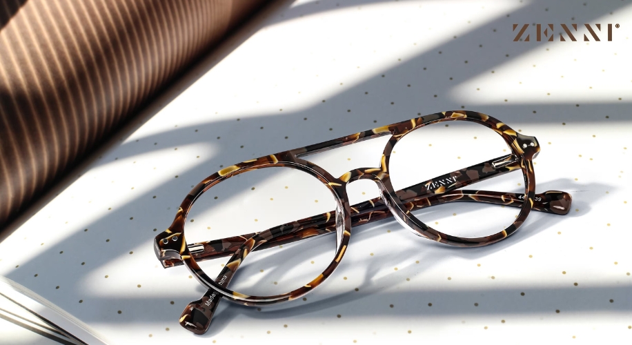 Tortoiseshell round glasses by ZENNI placed on a dotted surface.