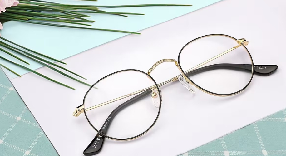 Gold round eyeglasses with black temple tips. Text on the left temple reads &quot;Zivanz&quot; and &quot;Made in China.&quot;