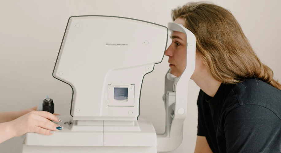 Person using an autorefractor machine for an eye exam.