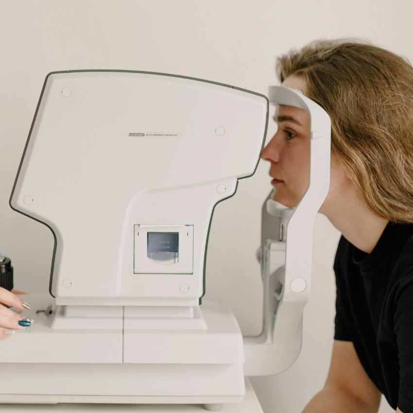 Patient using an auto refractometer for eye examination.