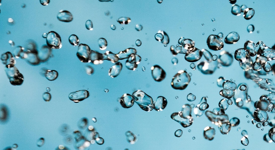 Floating water droplets against a light blue background.